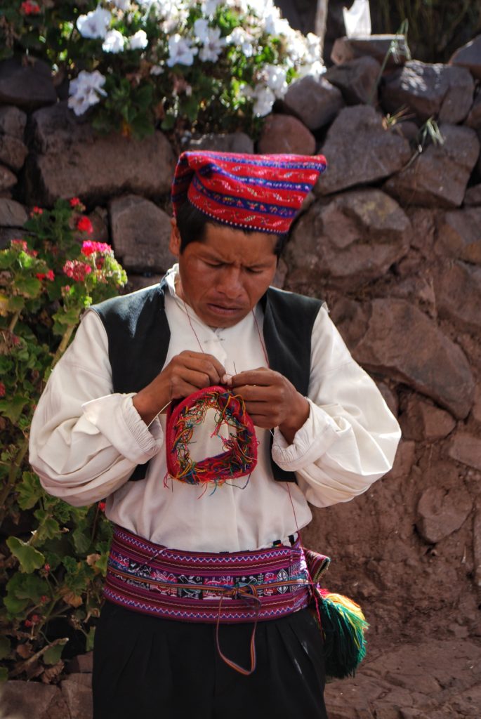 Artigiano in abiti tradizionali sull'isola di Taquile sul lago Titicaca